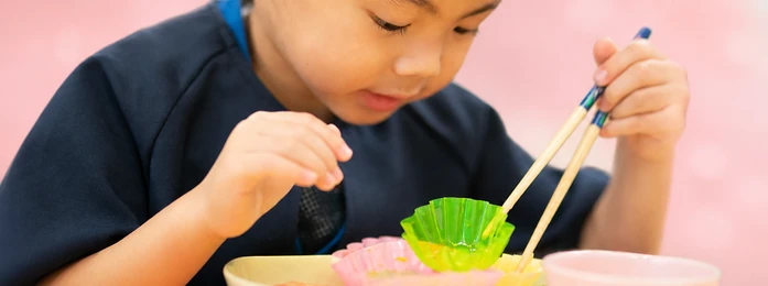 おやつの皿とコップを前にする子どもの手元