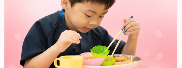 おやつの皿とコップを前にする子どもの手元