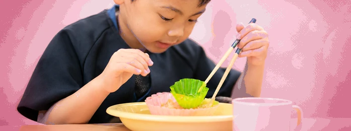 おやつの皿とコップを前にする子どもの手元
