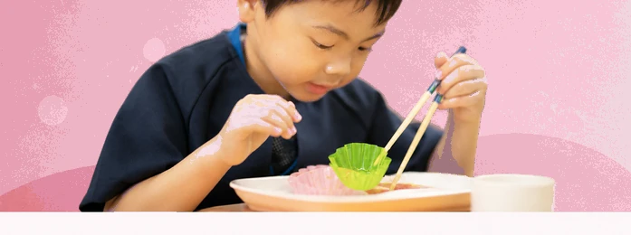 おやつの皿とコップを前にする子どもの手元