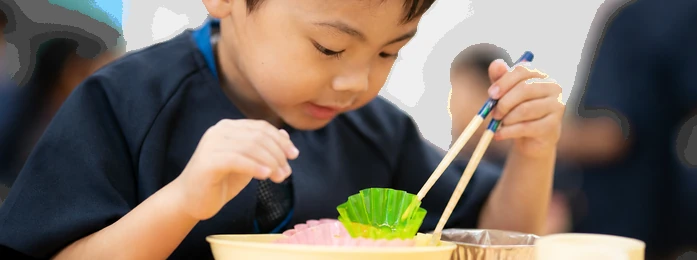 おやつの皿とコップを前にする子どもの手元