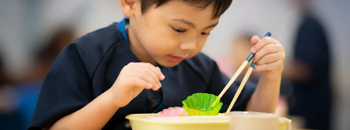 おやつの皿とコップを前にする子どもの手元